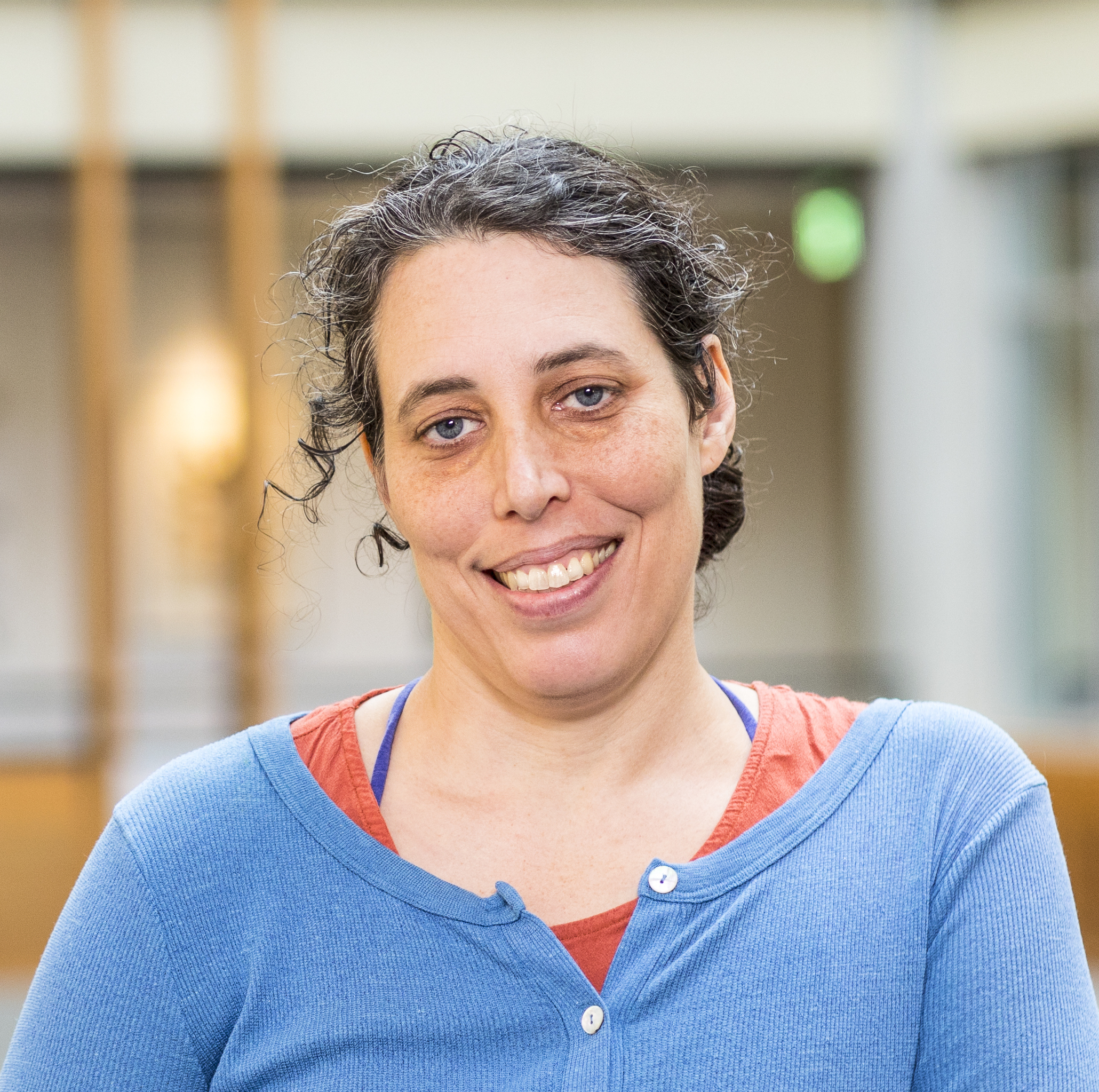 Jennifer Mankoff, a white, Jewish woman. She is smiling broadly and standing casually in the Allen Center atrium