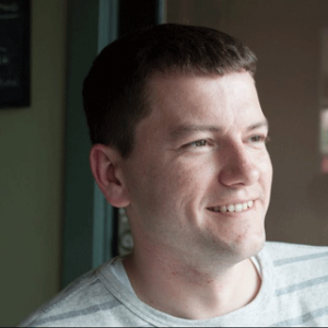 Candid photo of James Fogarty smiling. He is a white man with, in this photo, neatly combed short brown hair.