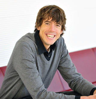 Photo of Jon Froehlich leaning forward in his seat and smiling effusively. He is a white man with brown hair.