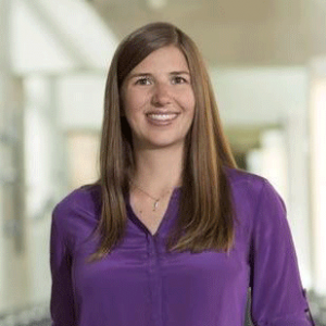 Headshot of Kat Steele, smiling warmly. She is a white woman with long brown hair.